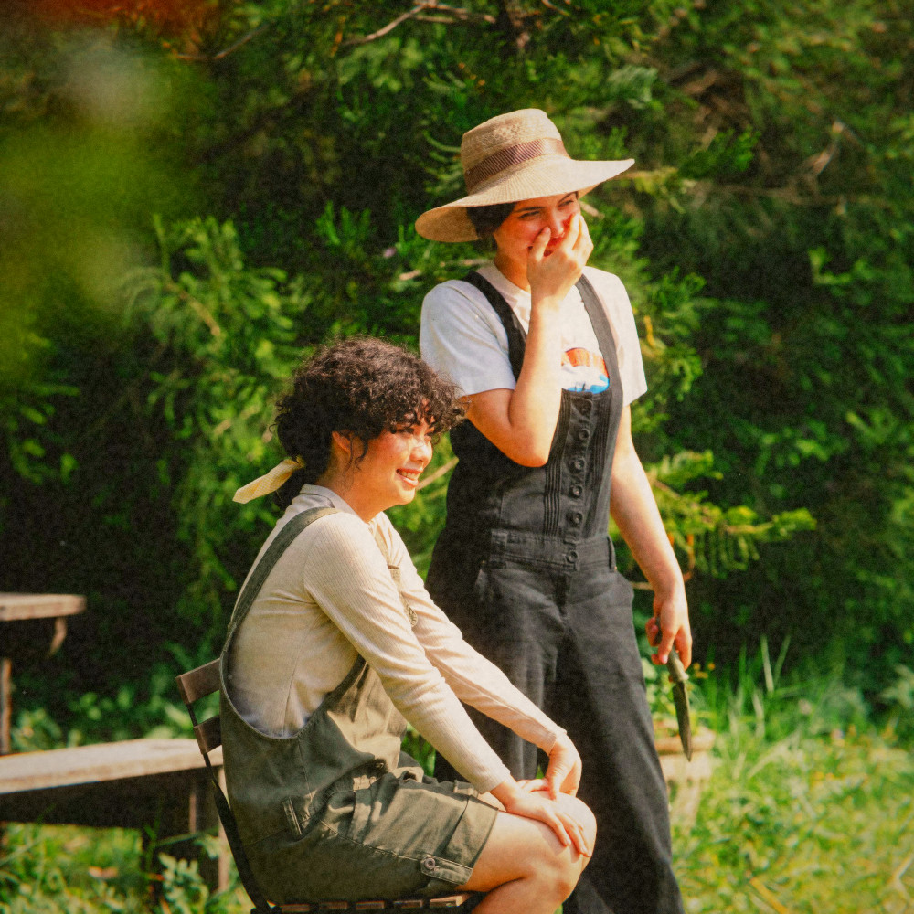 Two friends laughing in a garden, 1972 look