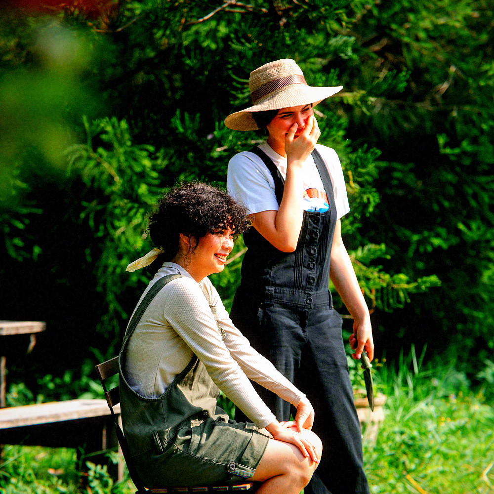 Two friends laughing in a garden, 2004 look